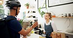 Phone, barista or delivery man in coffee shop or cafe for drinks, food or package at checkout counter in a store. Courier app, bicycle helmet or waitress in small business with a mobile, woman or guy