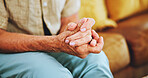 Senior, woman and closeup of hands on sofa in home with nostalgia, reflection or thinking of memory in retirement. Elderly person, wrinkles and mental health with alzheimers in living room of hospice