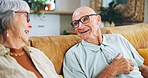 Senior couple, talking and happy on sofa with memory, care and bonding with love in home living room. Elderly woman, old man and smile for conversation, connection and retirement on couch in house