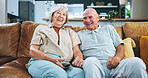 Senior couple, watching tv and portrait on sofa for smile, remote control or relax in living room. Elderly woman, old man and happy on lounge couch for streaming, movie or film in home for retirement