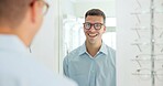 Man, glasses and mirror at store for eye care, vision and wellness for eyesight, smile and choice. Person, customer and check reflection with decision for optometry, happy and style at retail shop