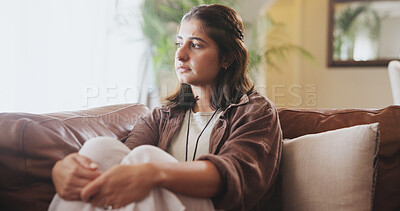 Buy stock photo Mental health, unhappy and woman with depression, sad and thinking on sofa in living room, house and home. Anxiety, emotional and concerned girl with stress, moody and miserable person on couch