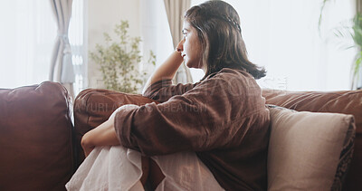 Buy stock photo Mental health, thinking and woman with depression, sad and unhappy on sofa in living room, house and home. Anxiety, emotional and concerned girl with stress, moody and miserable person on couch