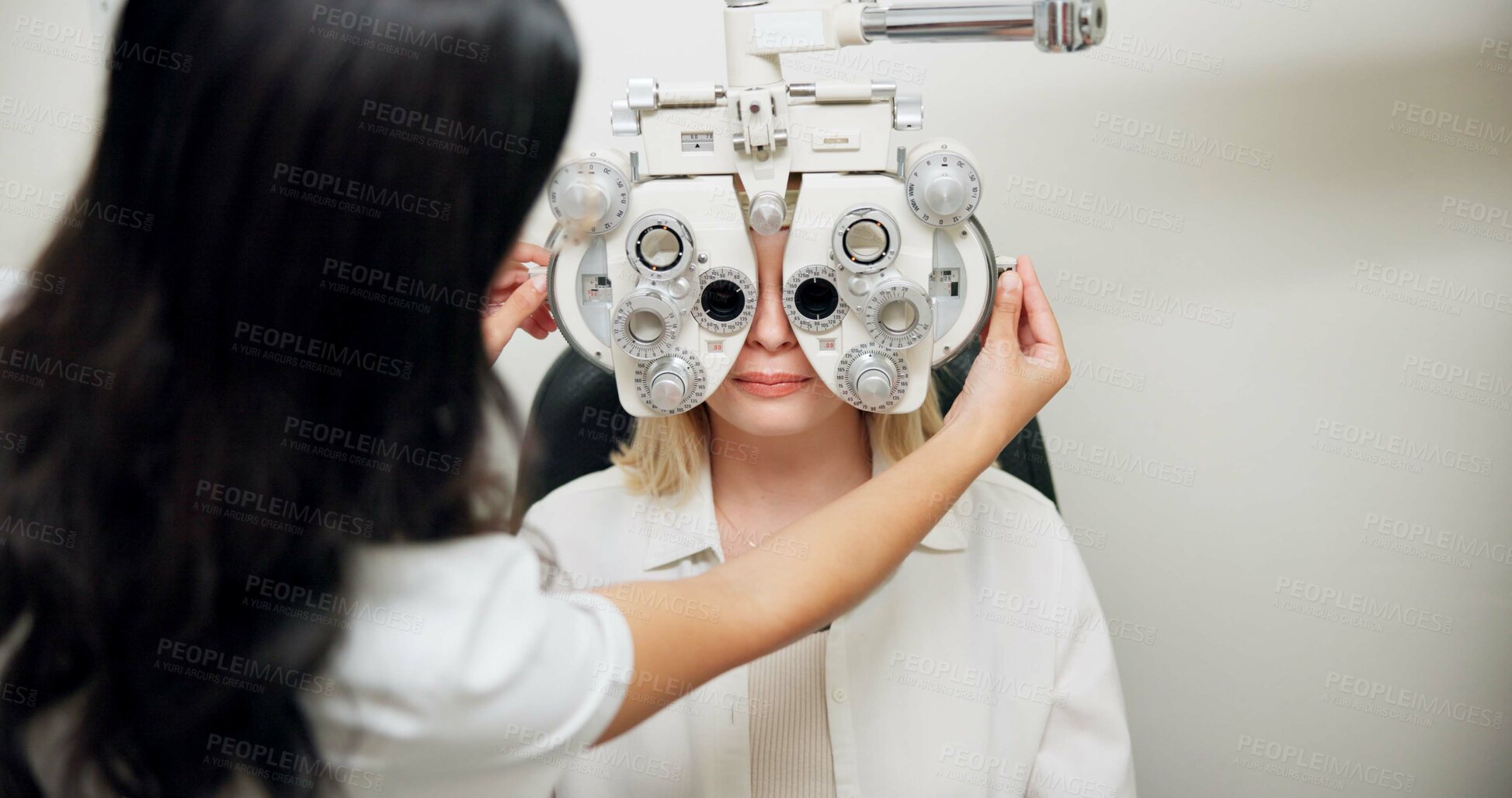 Buy stock photo Optometrist, woman and phoropter for eye exam, vision and wellness in consultation room at hospital. People, doctor and patient with machine, lens and assessment for healthy eyesight in clinic