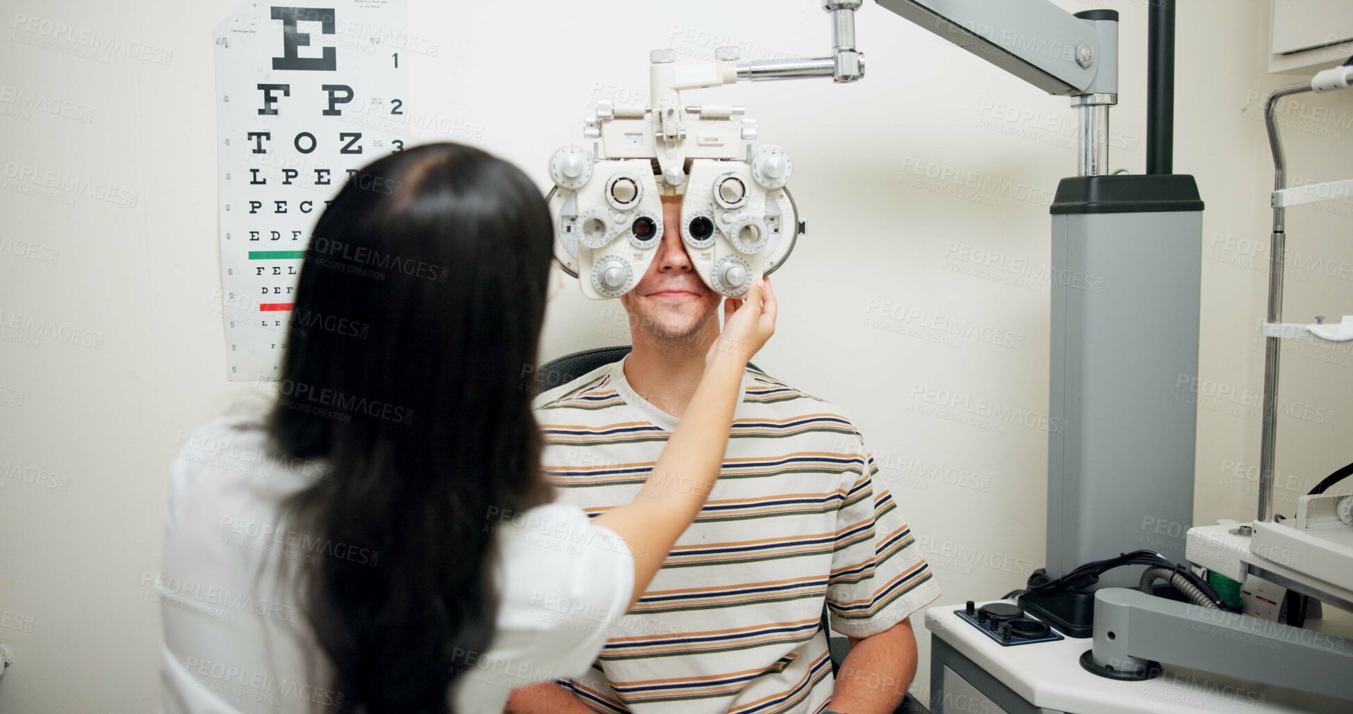 Buy stock photo Optometrist, man and phoropter for eye exam, vision and wellness in consultation room at hospital. People, doctor and help patient with machine, lens and assessment for healthy eyesight in clinic