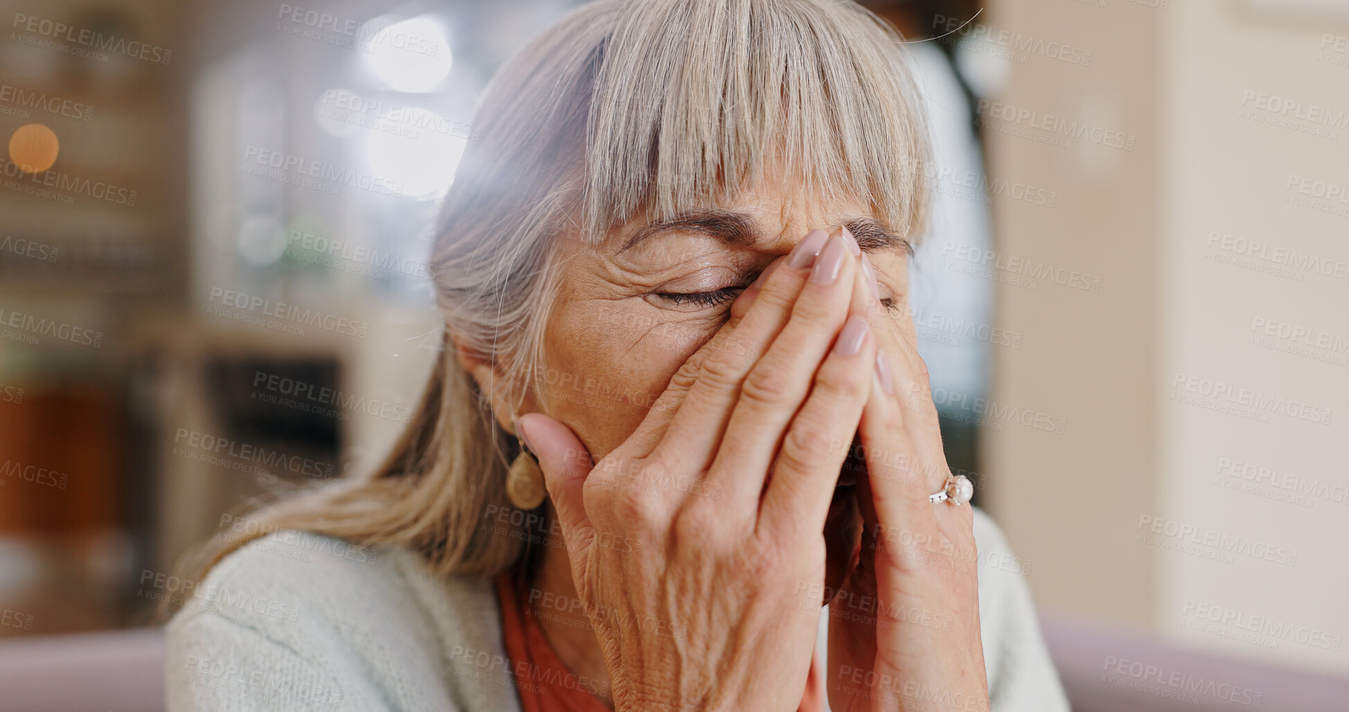 Buy stock photo Senior woman, crying and sad in lounge, hand and memory of past, retirement and depression in nursing home. Grandma, lonely and couch of house, remember and elderly person in living room and grief