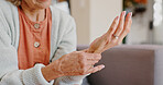 Medical, wrist pain and senior person with arthritis, osteoporosis and fibromyalgia on sofa. Home, lounge and woman with hands massage for discomfort, bruise muscle and carpal tunnel in retirement