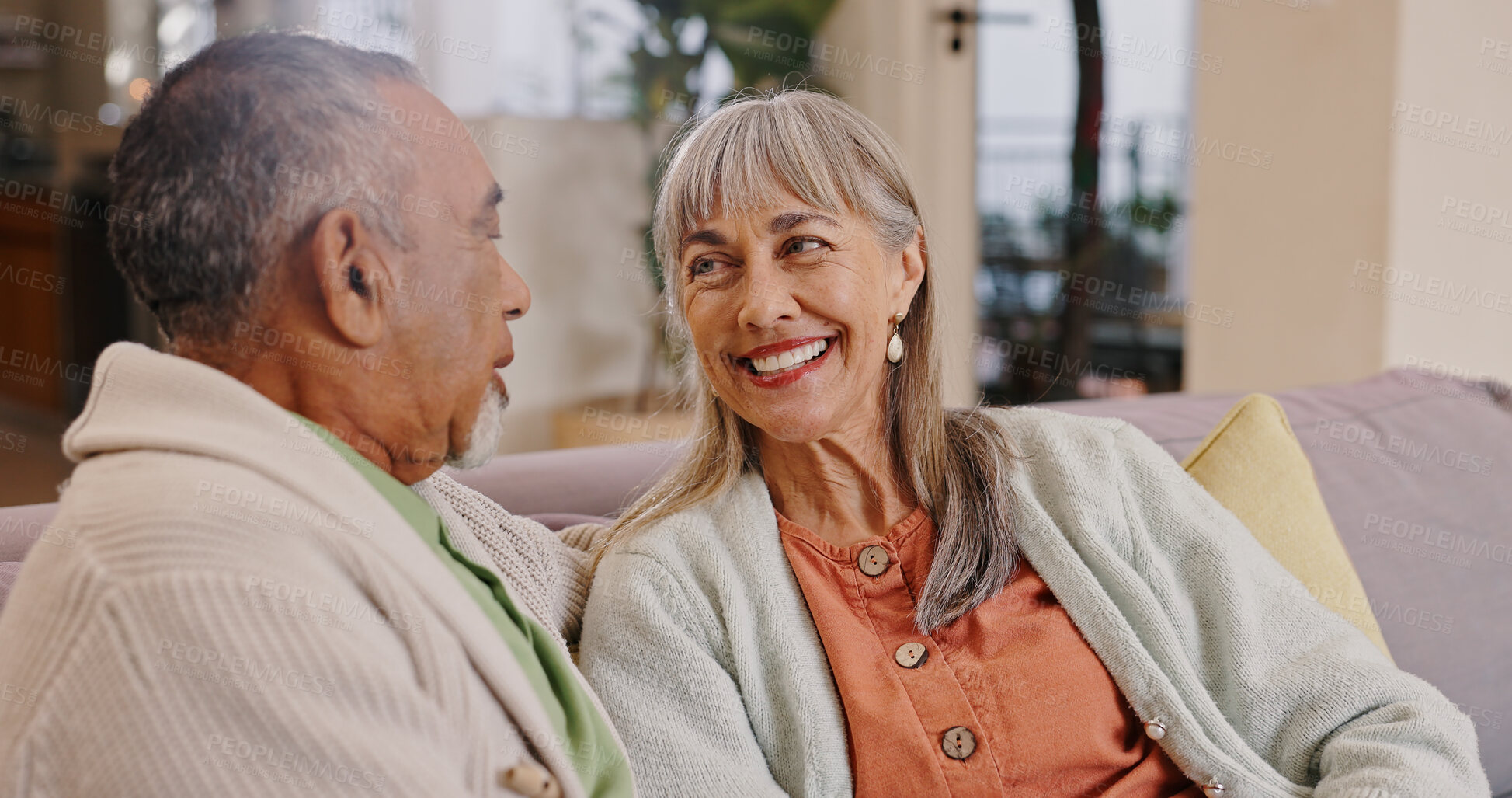 Buy stock photo Elderly couple, talking and smile in lounge, couch and relax in retirement, weekend and romance in house. Love, old man and woman in living room, chat and bonding in apartment, people and marriage