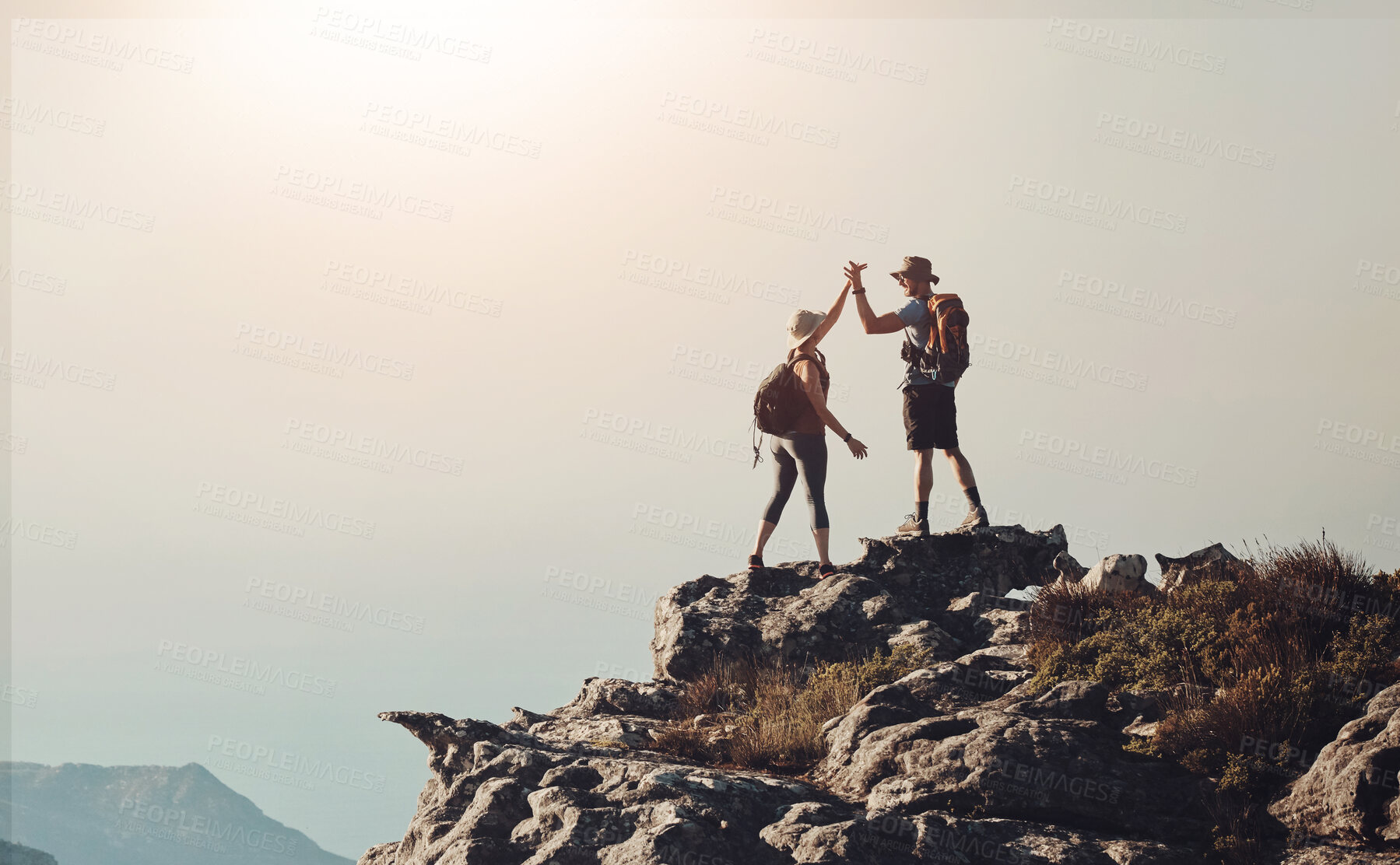 Buy stock photo Hiking, high five and couple on mountain cliff with backpack for adventure, trekking and fitness. Travel, nature and happy people for wellness and exercise achievement on holiday, mockup or vacation