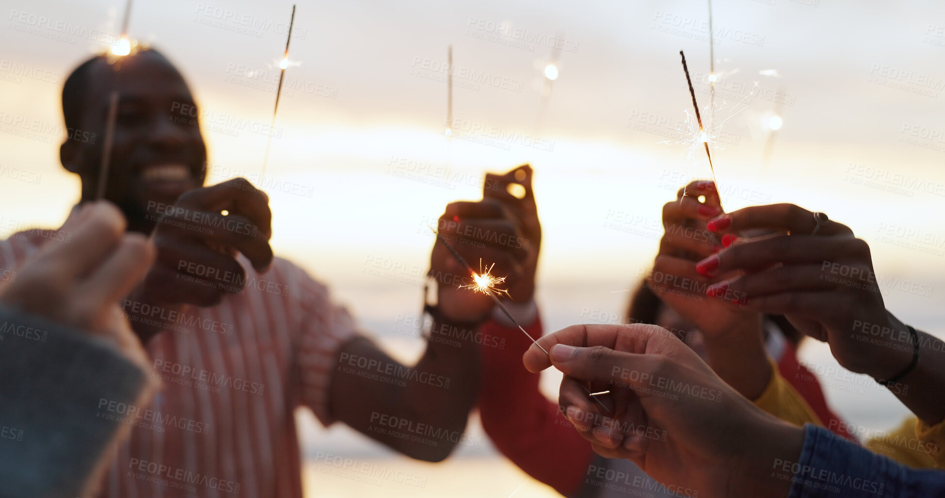 Buy stock photo Outdoor, sparkler and group of people with happiness at party, celebration with friends on vacation. Crowd, smile and fireworks on island holiday in Bali for travel, together for festival at sunset