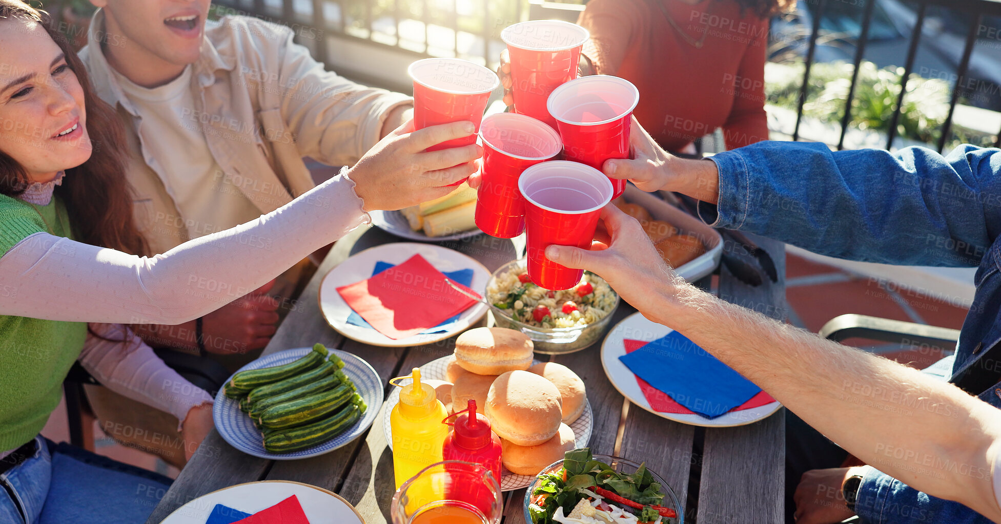 Buy stock photo Cheers, drinks and group of friends outdoor for fourth of July celebration, social event or party. Toast, American flag and young people with alcohol bonding together at barbecue for weekend.