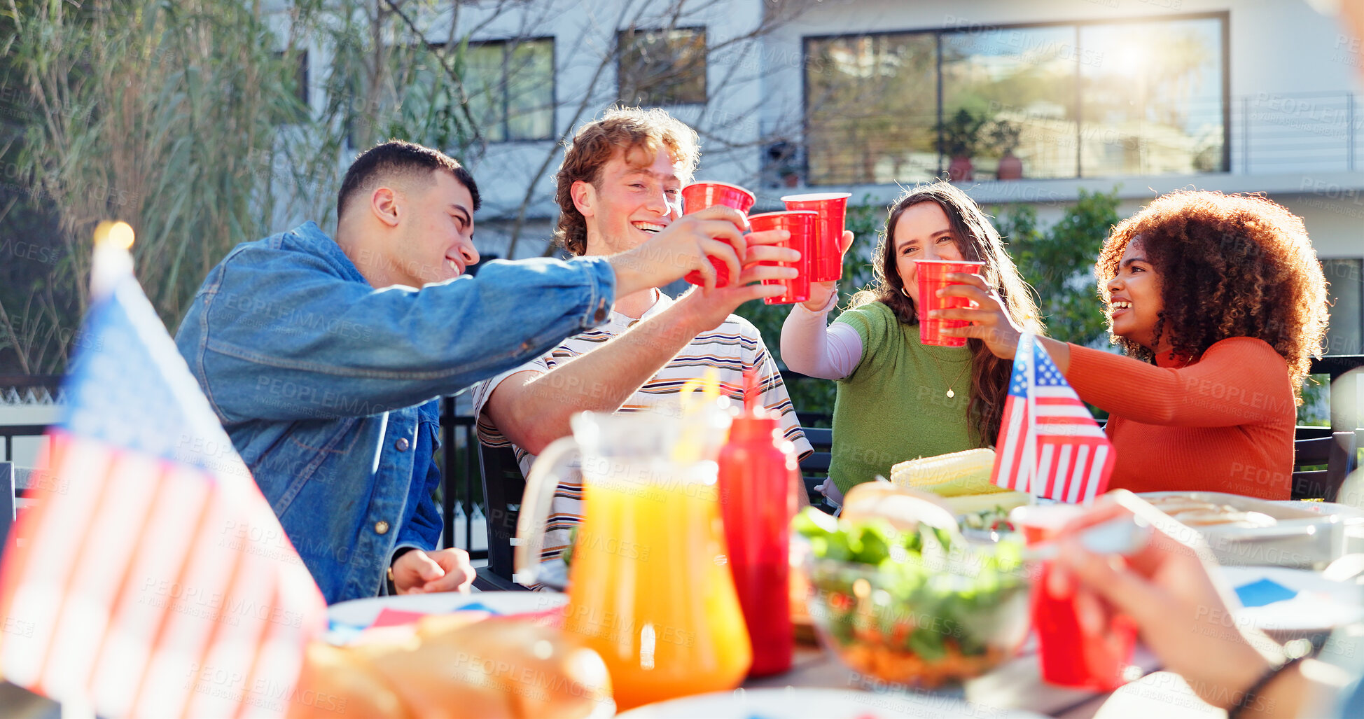 Buy stock photo Cheers, alcohol and group of people outdoor for fourth of July celebration, social event or party. Toast, American flag and young friends with drinks bonding together at barbecue for weekend holiday.