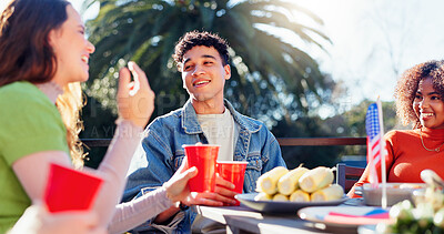 Buy stock photo Discussion, alcohol and group of friends outdoor for fourth of July celebration, social event or party. Talking, American flag and young people bonding together at barbecue on terrace for weekend.