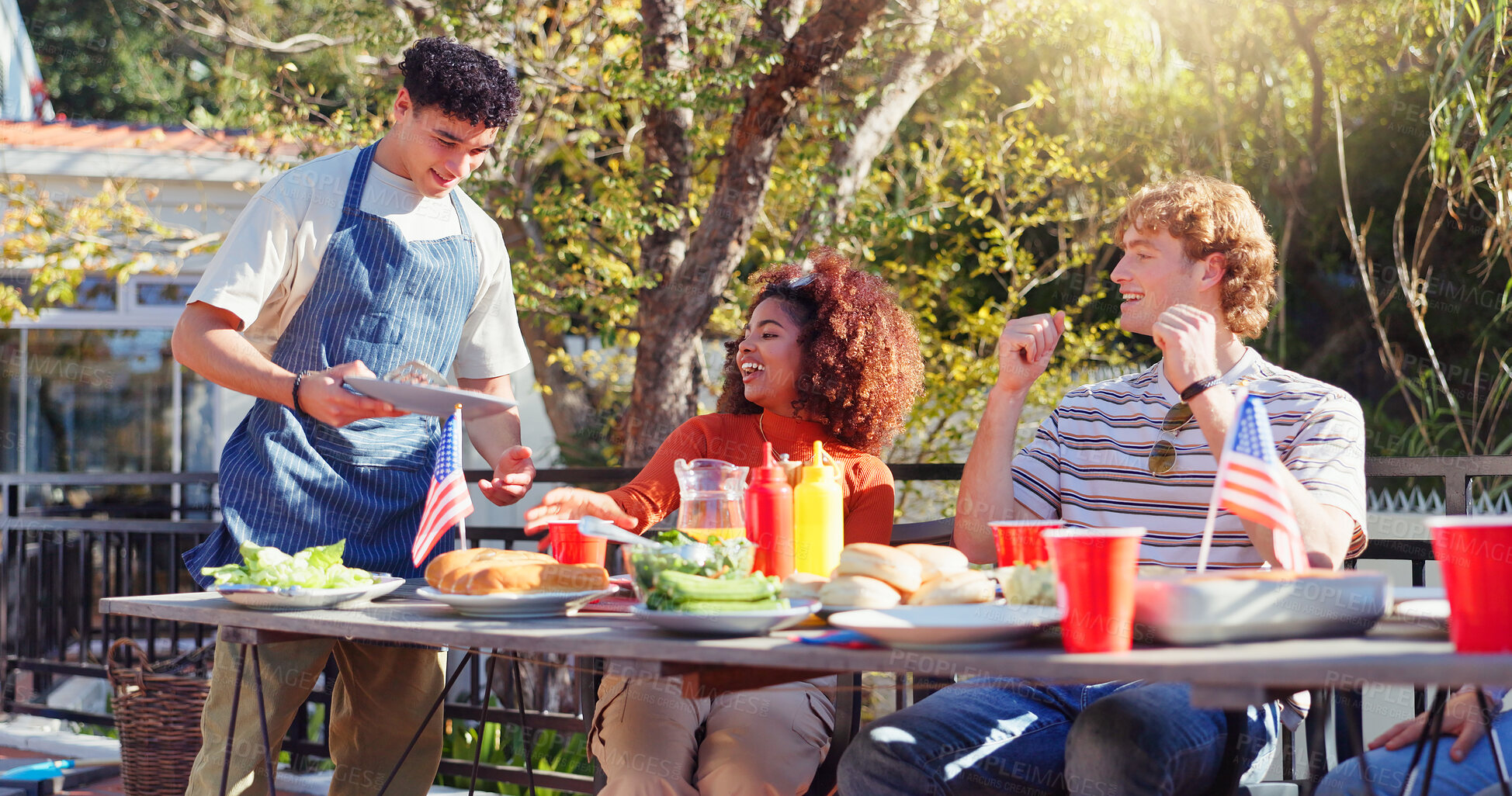 Buy stock photo Friends, group and eating barbecue outdoor on terrace with conversation, reunion and social event in summer. People, bbq and lunch on patio with food, talking and celebration with bonding and drinks