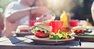 Buy stock photo Hamburger, food and salad on plate outdoor at reunion lunch for national independence day. American flag, vegetables and patty on bun by wooden table for United states holiday event in backyard.