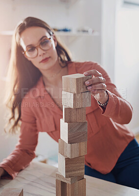 Buy stock photo Woman, home and serious on desk with building blocks for problem solving, solution and educational. Female person, house and cubes with ideas, strategy and foundation for growth and creative