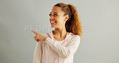 Buy stock photo Woman, happy and pointing away in studio background with mockup space for advertising or promotion. Female person, smile and satisfied with gym wear for instruction or tips and isolated for marketing