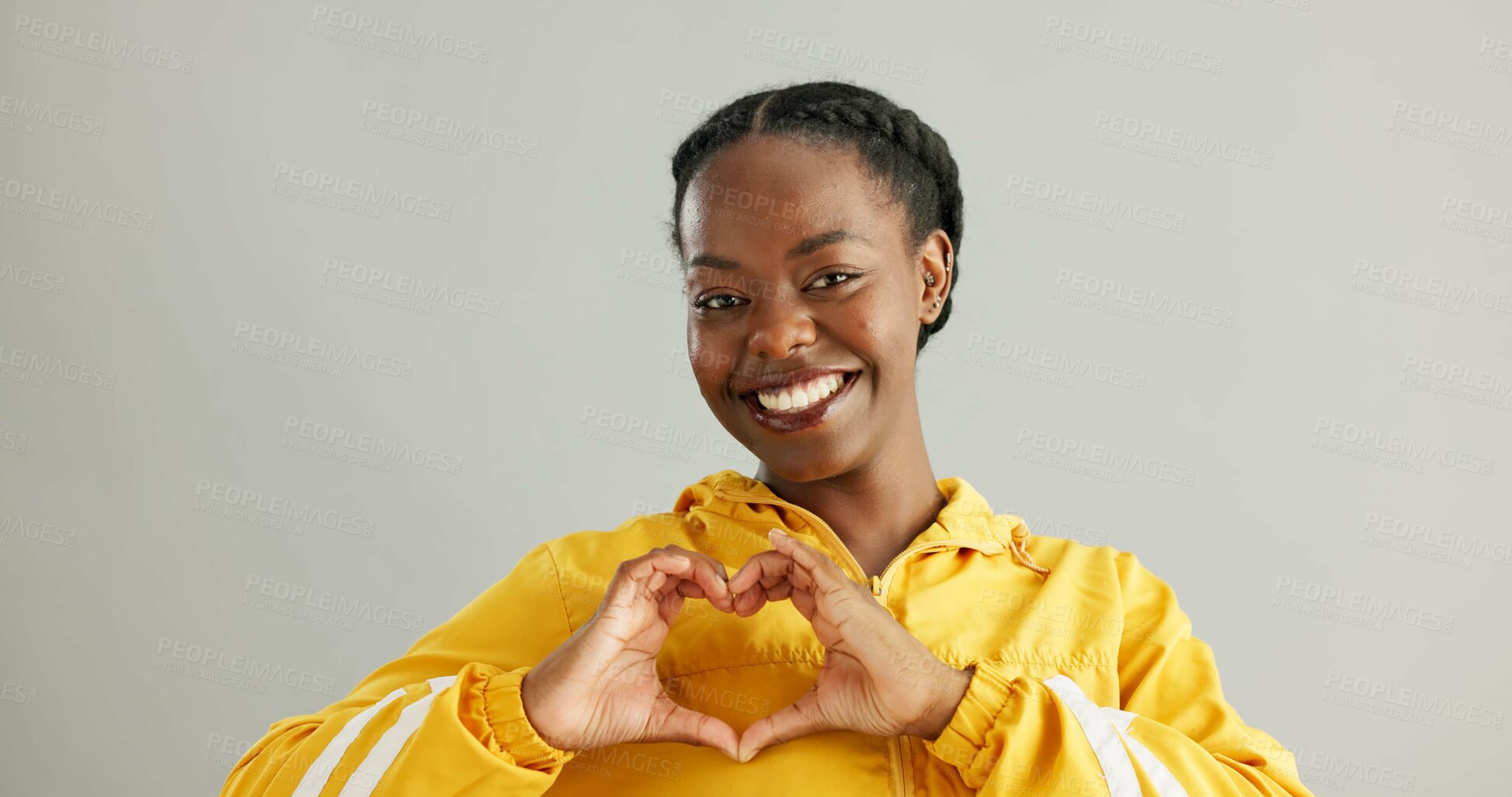 Buy stock photo Black woman, studio and heart sign for fashion with smile, sustainable or eco friendly clothes for wellness. Female person, gray background and hands with love gesture, cool portrait in New York