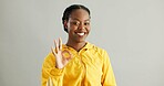 Portrait, black woman and OK sign with smile, success and approval on grey studio background. African person, face or model with hand gesture, like and emoji with icon, yes or agreement with feedback