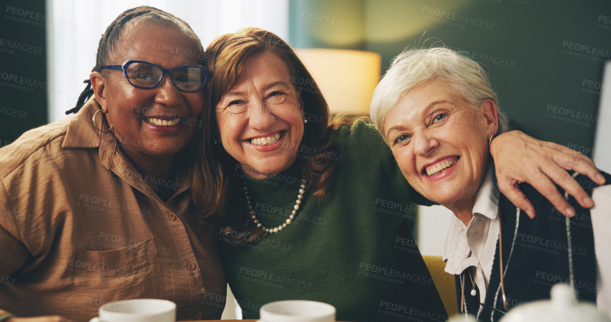 Buy stock photo Happy, hug and portrait of senior women in house with care, trust and support, relax and bonding with coffee. Smile, face or elderly friends embrace in retirement home for reunion, visit or tea party