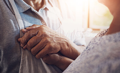 Buy stock photo Cropped shot of a mature man holding his wife’s hand close to his heart in the kitchen at home