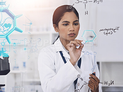 Buy stock photo Cropped shot of an attractive young female scientist working on formulas in her laboratory