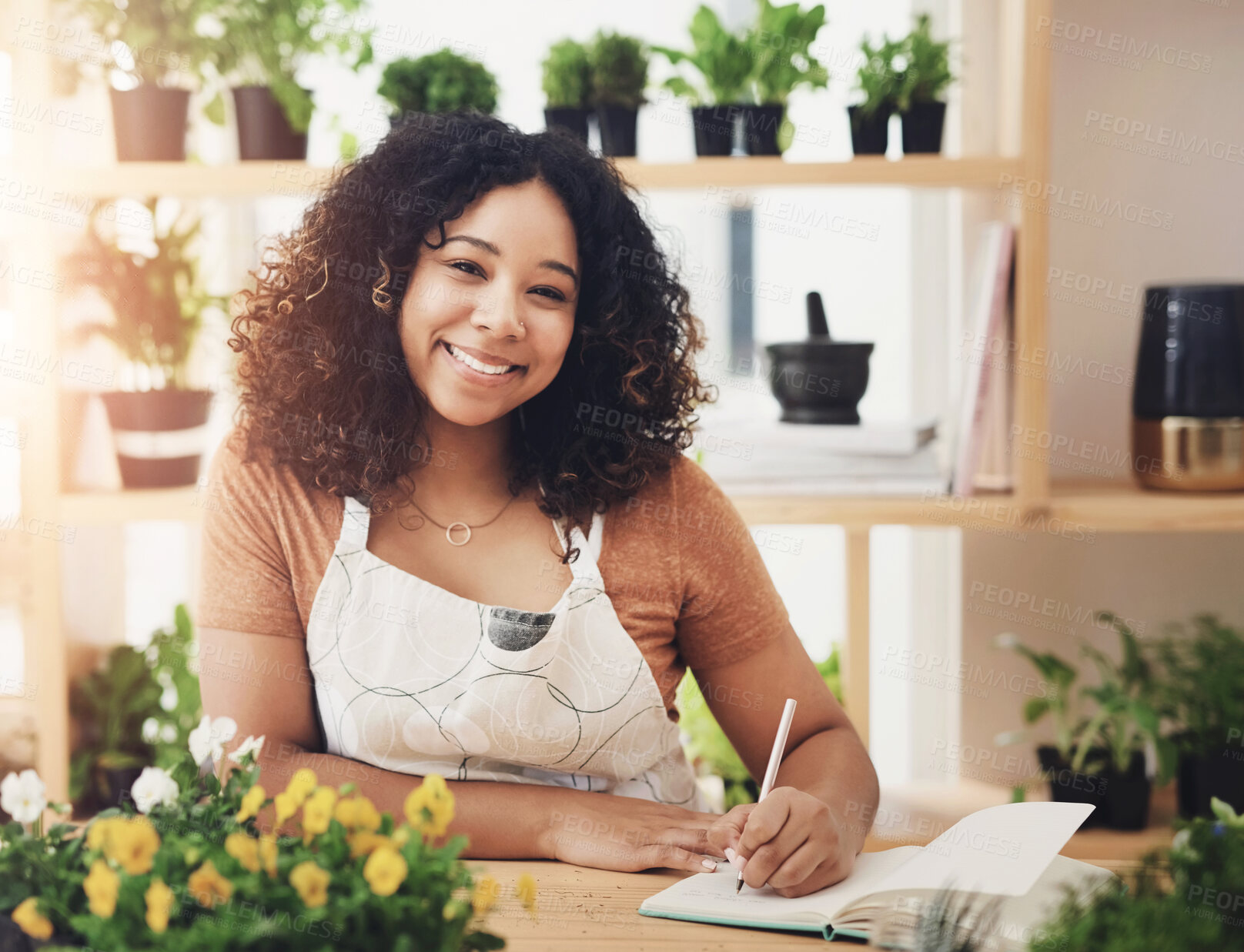 Buy stock photo Cropped portrait of an attractive young female botanist making notes while working in her florist