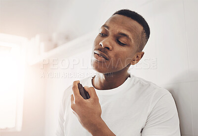 Buy stock photo Shot of a young man spraying himself with deodorant