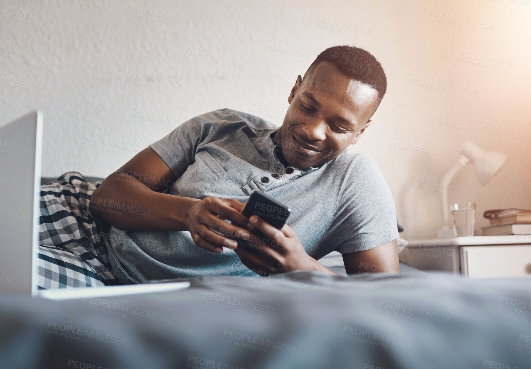 Buy stock photo Relax, phone and black man on bed in morning for social media, online post and internet in home. Happy, wake up and person on smartphone for reading website, news and mobile app in bedroom on weekend