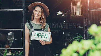 Buy stock photo Full length portrait of an attractive young business owner standing alone and holding the open sign at the floristry entrance