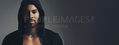 Buy stock photo Portrait of a handsome young man wearing a hoodie posing against a grey background