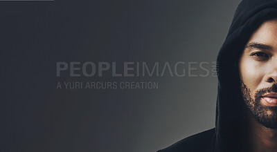 Buy stock photo Portrait of a handsome young man wearing a hoodie posing against a grey background