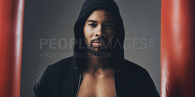 Buy stock photo Portrait of a handsome young man wearing a hoodie posing against a grey background