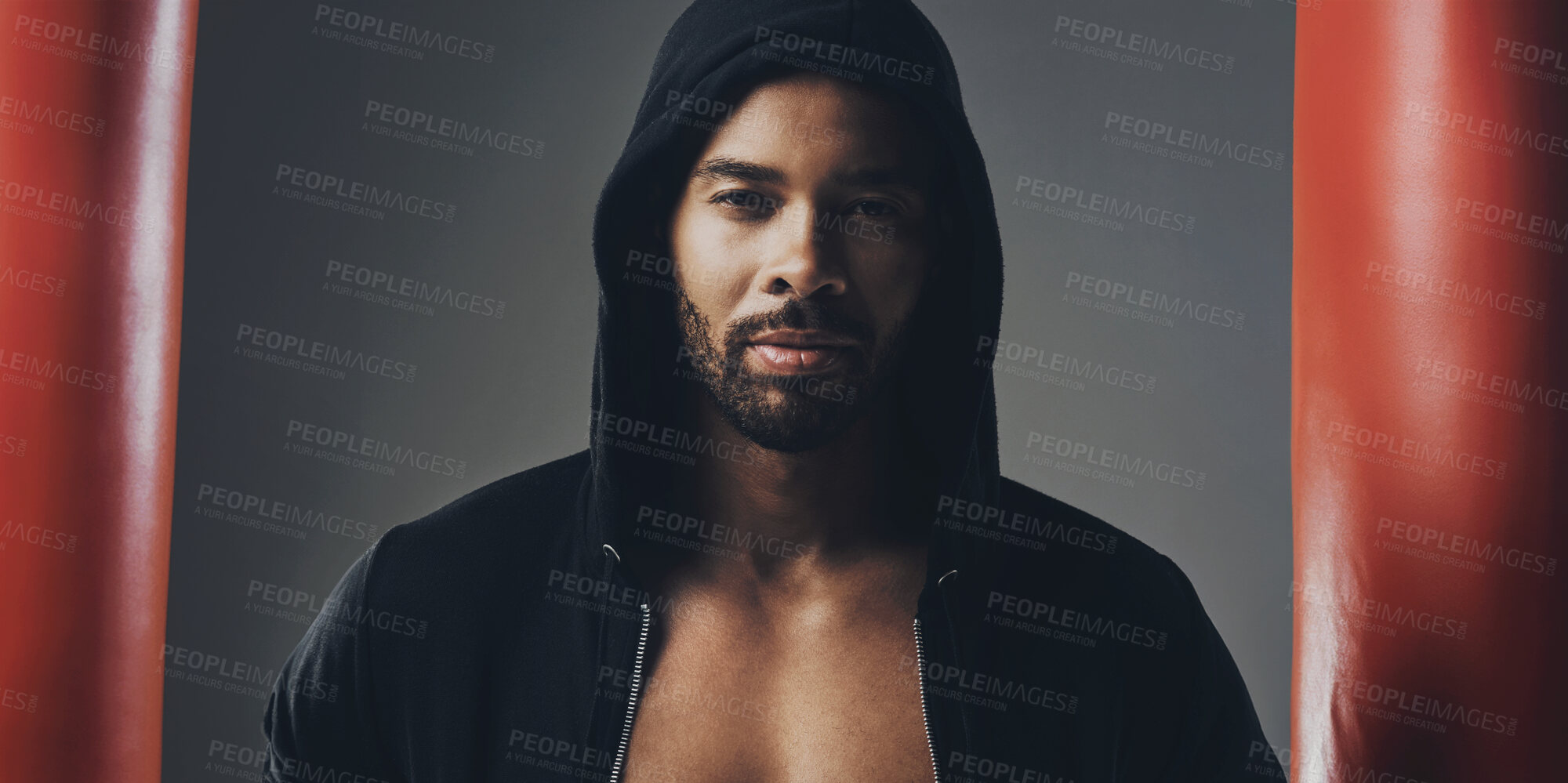 Buy stock photo Portrait of a handsome young man wearing a hoodie posing against a grey background