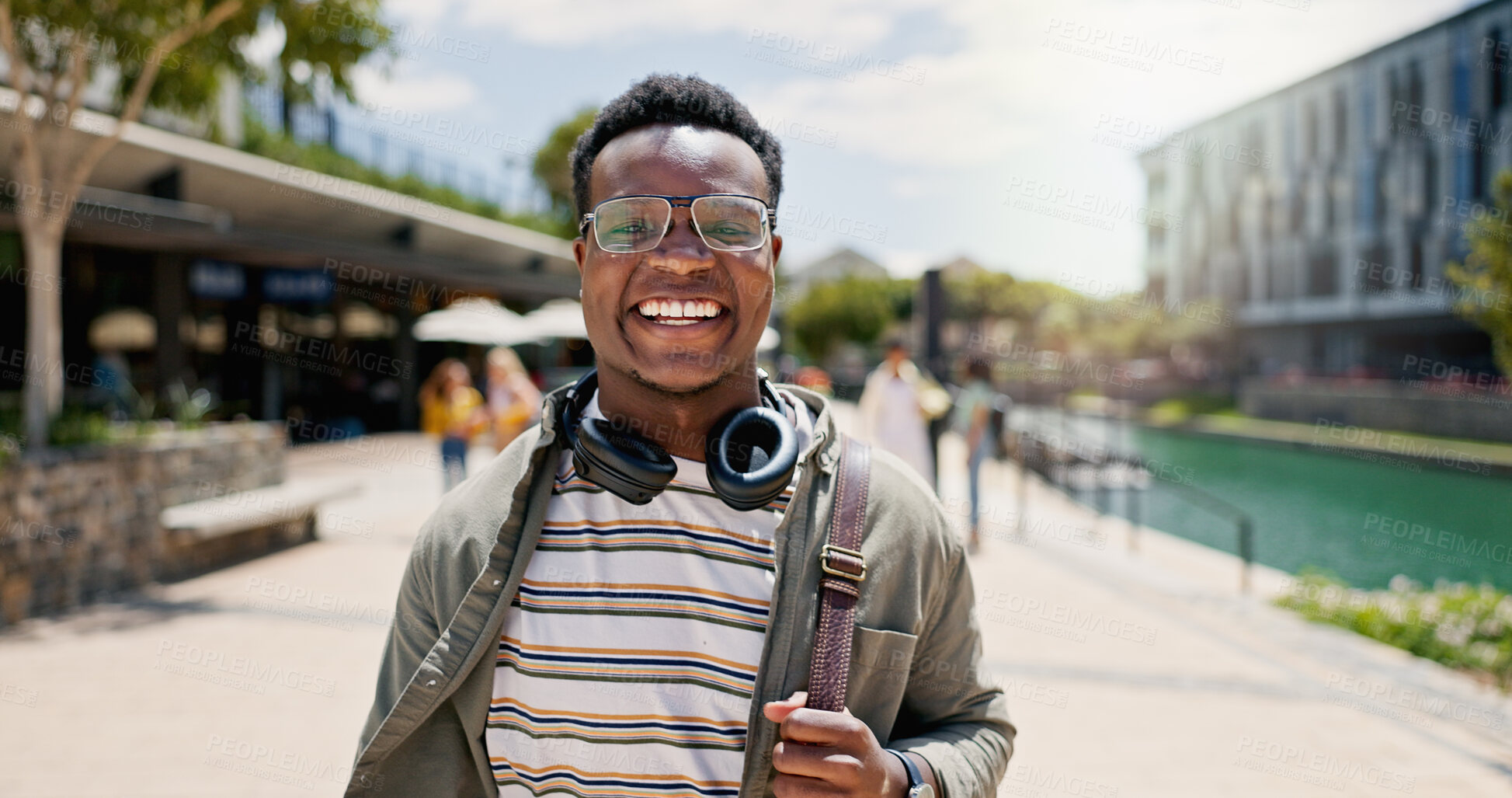 Buy stock photo Portrait, student and black man in city, smile and happiness with adventure, headphones and education. Face, African person and college with guy, headset and walking with break, travel and knowledge