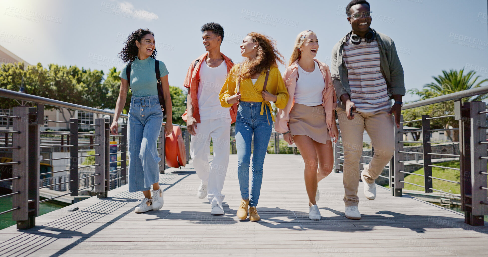 Buy stock photo Walking, conversation and friends at university with fun for learning, bonding and talking. People, diversity and group of gen z students on outdoor bridge ready for education at college campus.