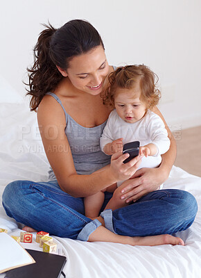 Buy stock photo Phone, playing and mom with baby on bed for bonding and watching video on social media together. Happy, love and young mother scroll on cellphone with girl child, kid or toddler in bedroom at home