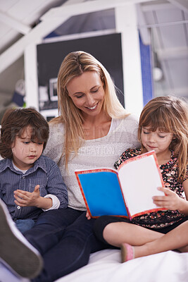 Buy stock photo Reading, mother and children on sofa with book for bonding, teaching and learning together in home. Woman, son and daughter relax on couch with storytelling, smile and happy family in living room