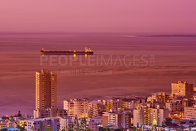 Buy stock photo Buildings, sunset and ocean or urban landscape with cityscape, boat and sea or outdoor. Development, skyline and port or dock for shipping, cargo and tourism or travel for architecture or hospitality