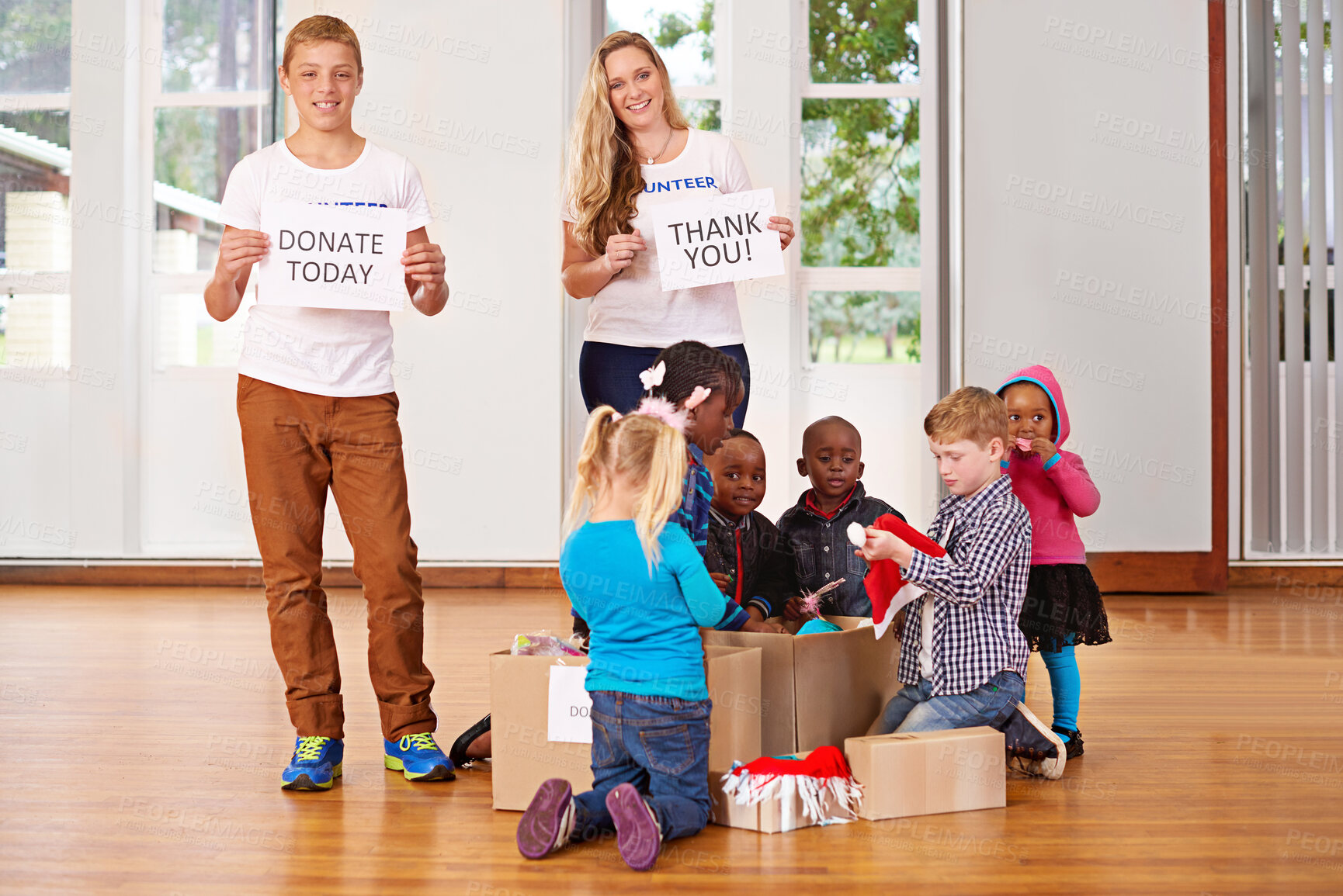 Buy stock photo Shot of volunteers working with little children