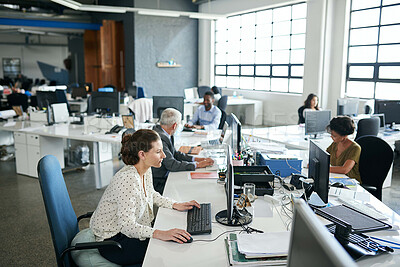 Buy stock photo Shot of colleagues working on their computers while sitting in an office