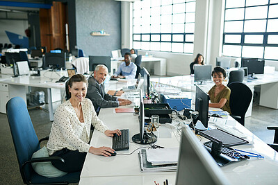 Buy stock photo Portrait of a group of coworkers sitting at their workstations in an office