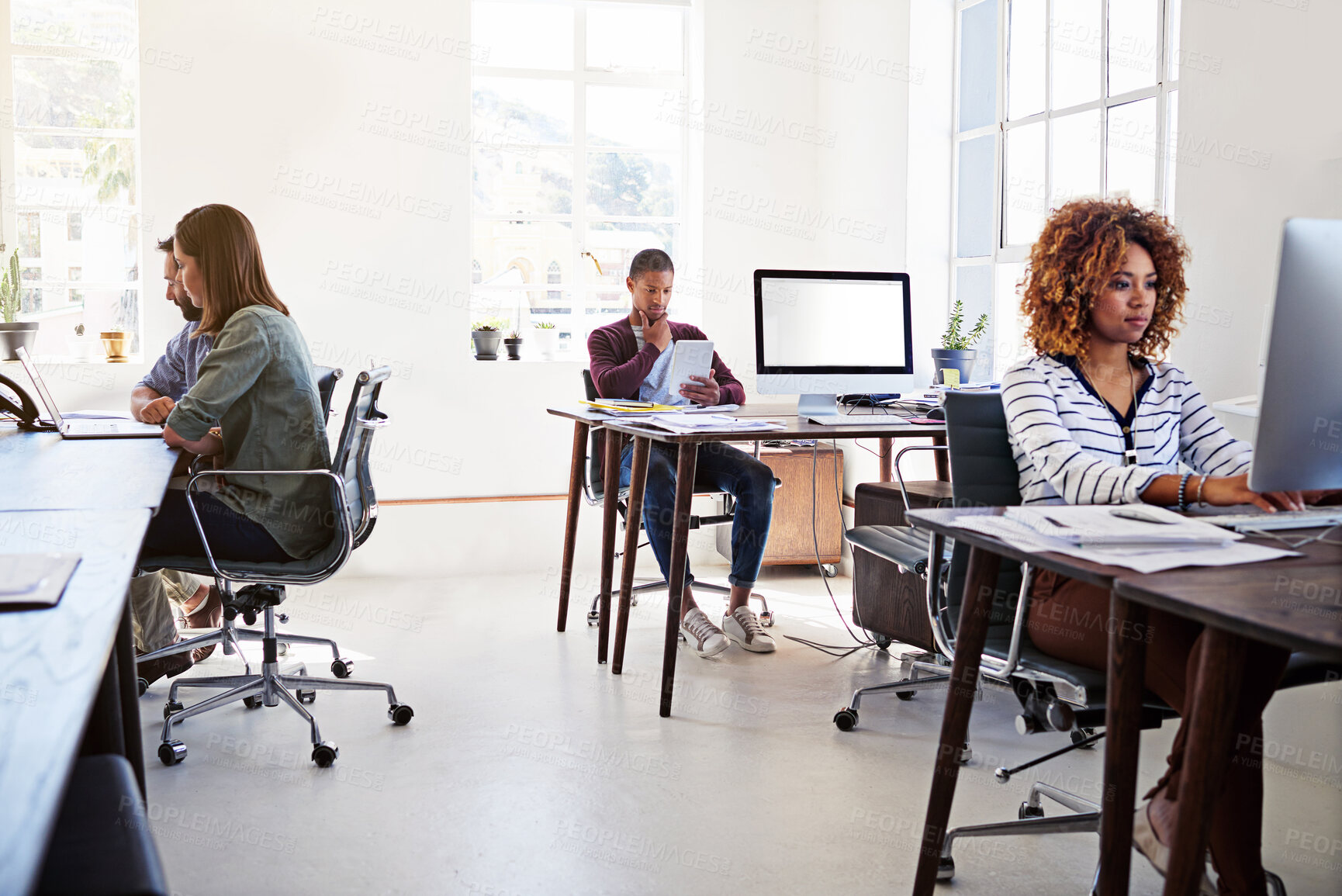 Buy stock photo Shot of colleagues working on their computers in an open plan office