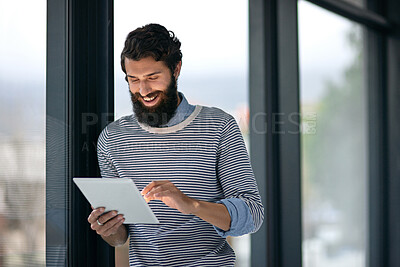 Buy stock photo Businessman, happy and online with tablet in office for web search, creative research or networking. Young professional, employee or intern copywriter with digital tech for project planning by window