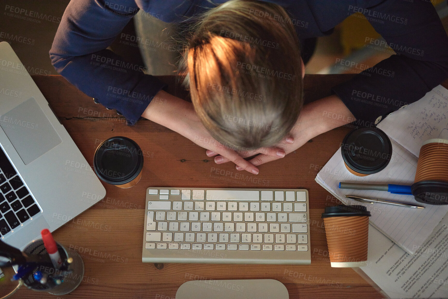 Buy stock photo Shot of a tired young designer napping on her desk wile working late in the office