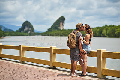 Buy stock photo Travel, couple and happy kiss with vacation, Bali and backpack for adventure by lake. People, together and love on holiday and park path outdoor with support, journey and romance on summer break