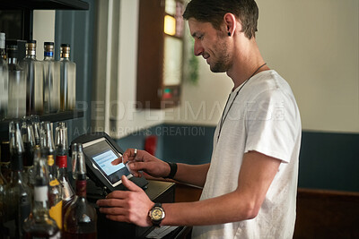 Buy stock photo Young man, bartender and order with pos system for receipt, checkout or register in liquor store. Male person or happy barman working on tablet screen for service, payment or checking transaction