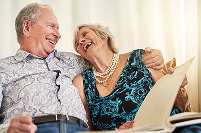 Buy stock photo Laughing, photo album and wedding with senior couple on sofa in living room of retirement home for love. Funny, history or nostalgia with elderly man and woman in apartment for bonding or romance