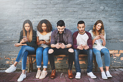 Buy stock photo Friends, connection and outdoor with phone for social network, support and communication by brick wall. Group of people, internet and community with technology for diversity, online and networking