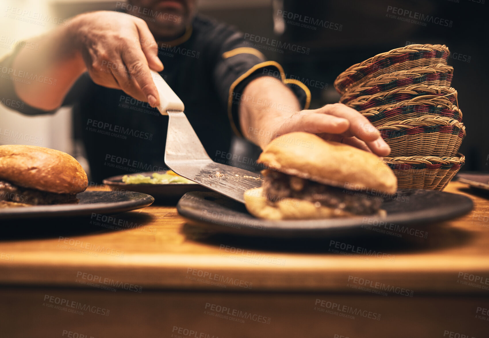 Buy stock photo Chef, person and hands in kitchen with hamburger, fast food and preparation on table. Male cook, meal and dinner of sandwich, order and culinary for hospitality service with cooking for professional